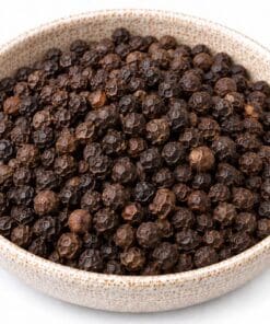 Hele zwarte peperkorrels in een kom