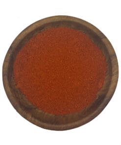 Felrood Carolina Reaper chilipoeder in een ronde houten kom