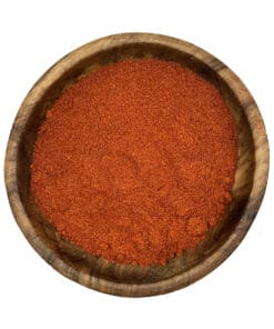 Houten kom gevuld met rode stoofpot kruiden, ideale Hongaarse kruidenmix voor goulash.