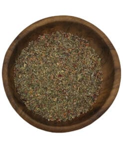 Grove American Steak Seasoning met paprika en groene kruiden in een houten kom