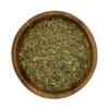 Houten kom gevuld met gedroogd fenegriekblad (kasoori methi) op een witte achtergrond.