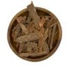 Houten kom gevuld met gedroogde Cassia-kaneelbast op een witte achtergrond.