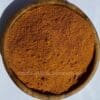 Houten kom met gemalen Berbere Ethiopische kruidenmix, ideaal om berbere te bestellen voor authentieke gerechten.