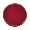 Houten kom gevuld met fijn rood bietenpoeder, perfect als natuurlijke kleurstof of voedingssupplement.