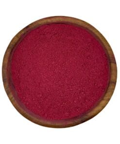 Houten kom gevuld met fijn rood bietenpoeder, perfect als natuurlijke kleurstof of voedingssupplement.