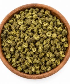 Groene Szechuanpeper in een ronde houten kom op een witte achtergrond.