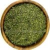 Houten kom gevuld met groene tzatziki kruidenmix, ideale Griekse kruiden voor authentieke tzatzikisaus.