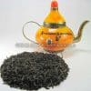 Theeverpakking Oranje Pecco ontbijtthee met losse theeblaadjes naast oranje decoratieve theepot.